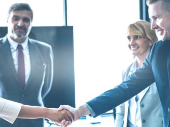 Business professionals shaking hands in a corporate meeting.